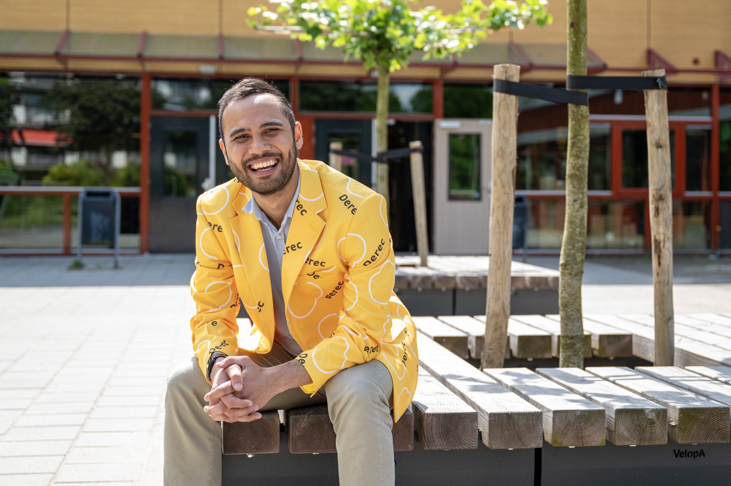 Kevin Sidin op een bankje voor middelbare school De Fontein in Bussum.