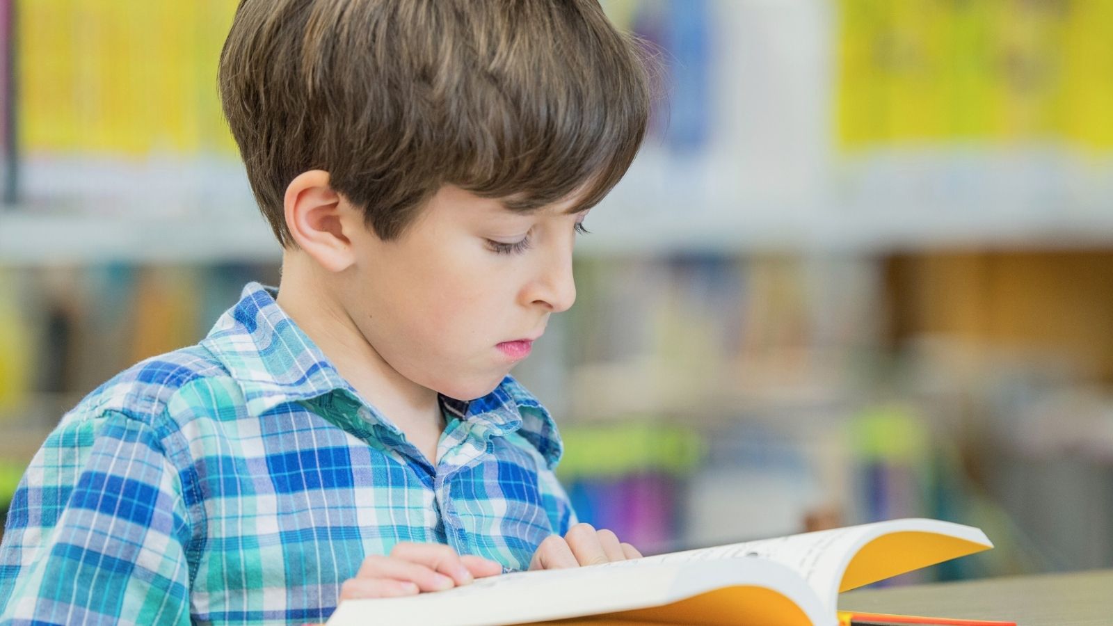 Jongen leest met taalgerichte lesmethode op school