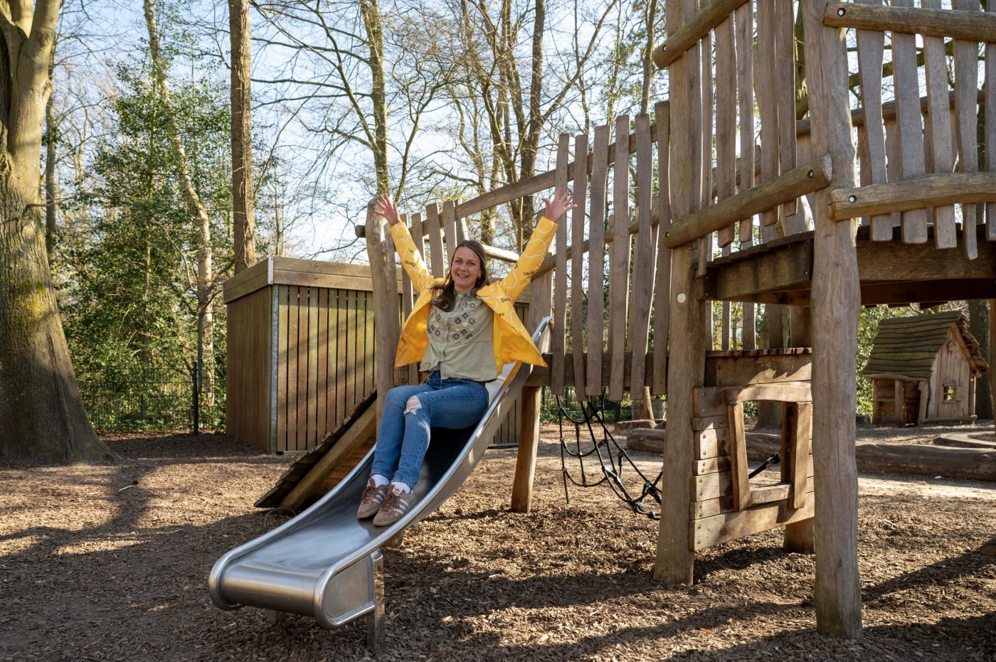 Blije leerkracht in de speeltuin van een basisschool.